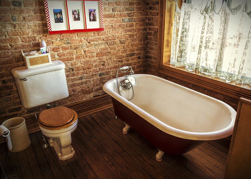 Un bagno d'epoca con un muro di mattoni rossi