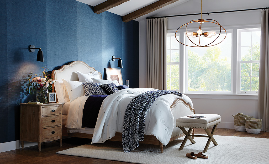 A grey and navy blue bedroom with sloped ceiling