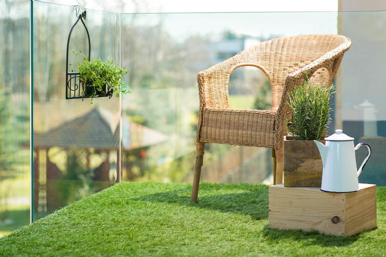 Sztuczna trawa na balkon - szklana balustrada