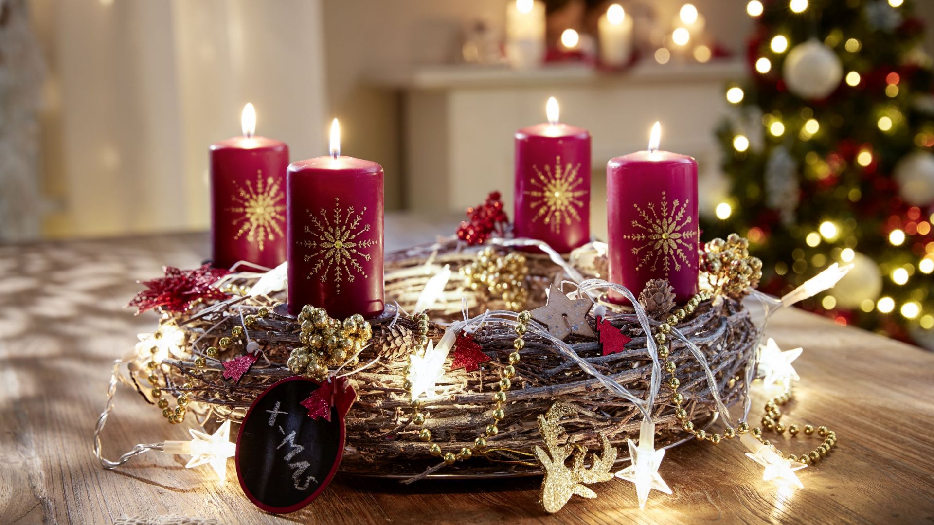 Рождественский венок с гирляндами и красными свечами