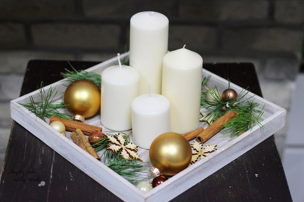 Weiß-goldener Weihnachtsschmuck auf einem Tablett