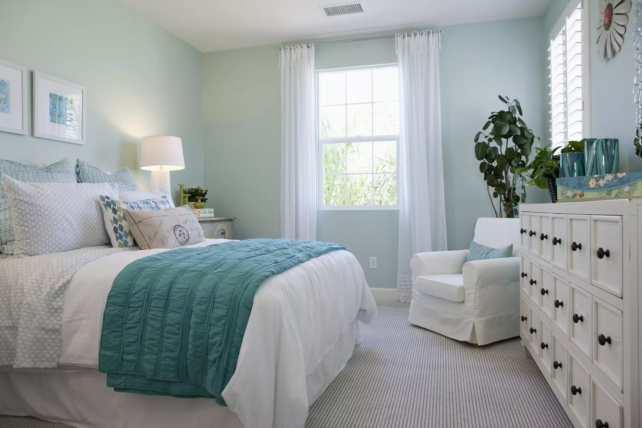 Sypialnia z białymi meblami i niebieskimi lub zielonymi dodatkami