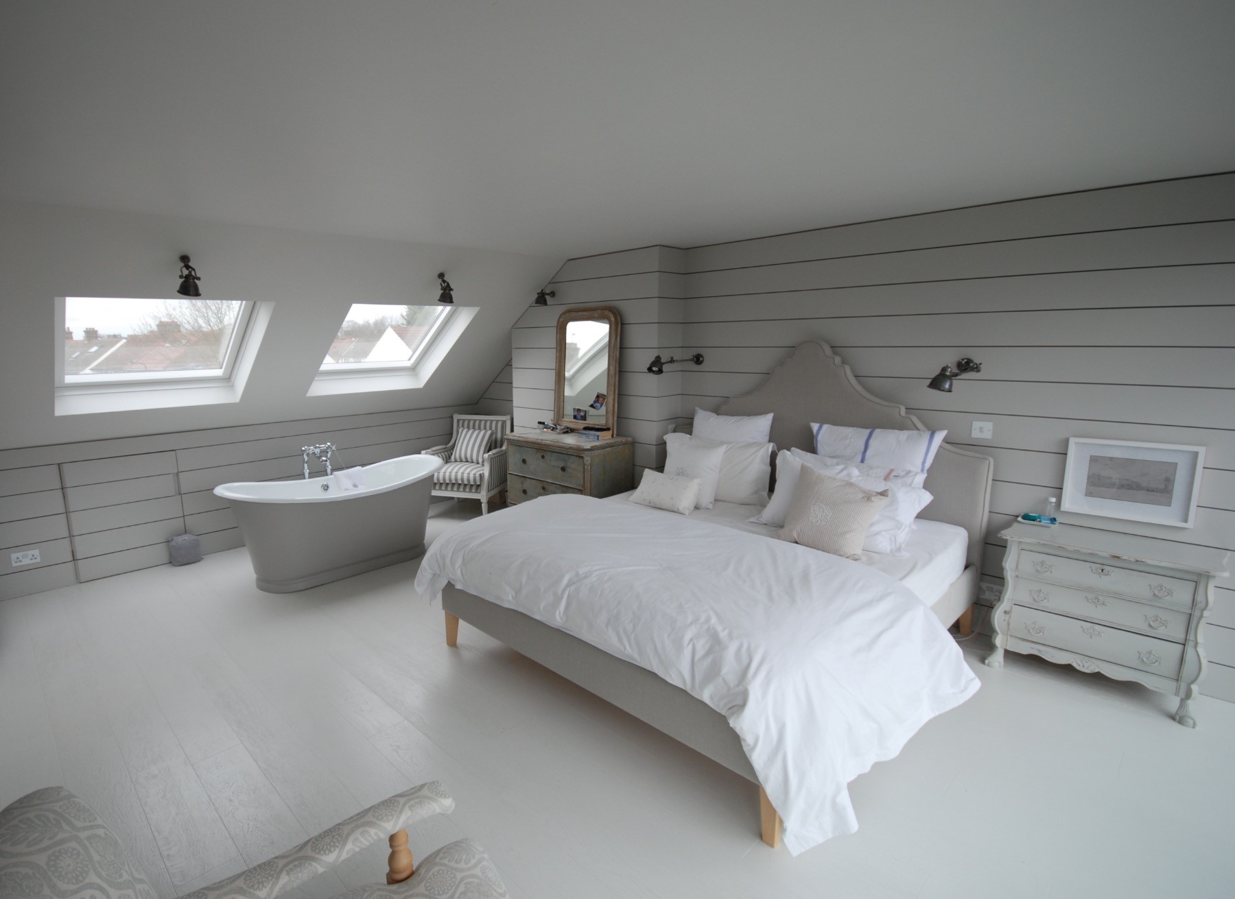 Ein minimalistisches Schlafzimmer im Dachgeschoss mit Bad